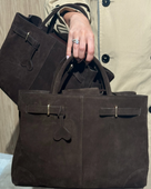 Person holding a brown leather suede luxury bag 